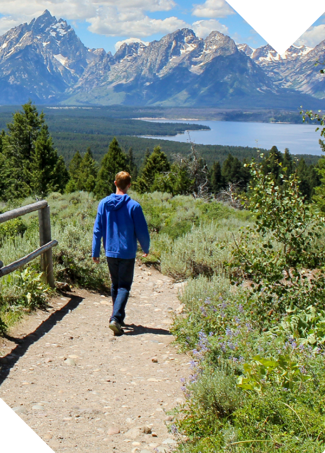 Upcoming events hero image. Image of a man hiking in the Grand Tetons.